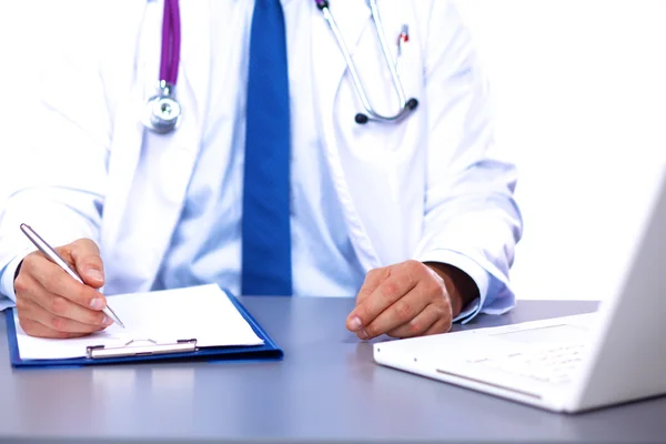 Doctor sentado en el escritorio de la oficina y toma notas — Foto de Stock