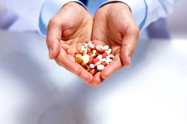 Csomagolási tabletták férfi orvos kinyújtja a kezét — Stock Fotó