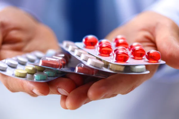 Упаковка таблетки мужчина врач растягивается в руке — стоковое фото