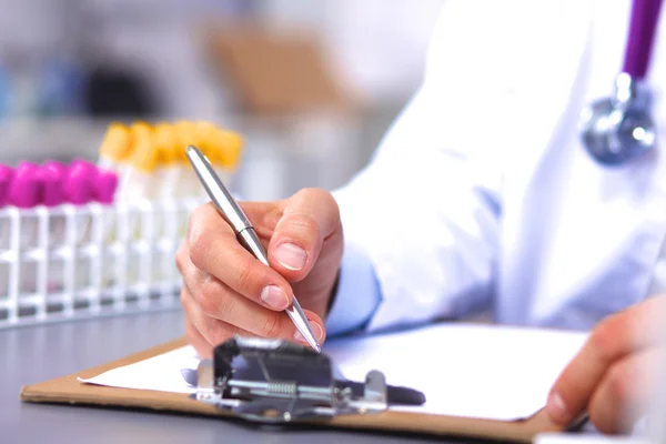 Médico sentado na mesa no escritório e toma notas — Fotografia de Stock