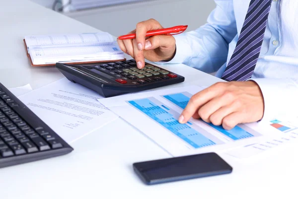 Big boss checks calculations on a calculator — Stock Photo, Image