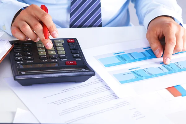 Big boss checks calculations on a calculator — Stock Photo, Image