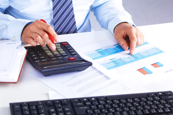 Big boss checks calculations on a calculator — Stock Photo, Image