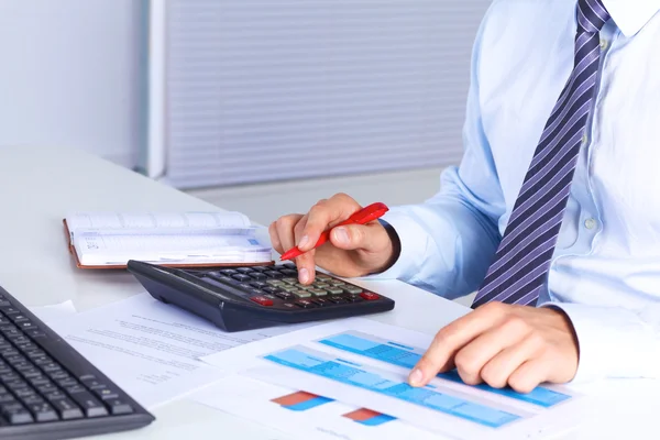 Big boss checks calculations on a calculator — Stock Photo, Image