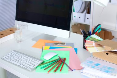 Bir bilgisayar ve evrak ile tasarımcı çalışma masası