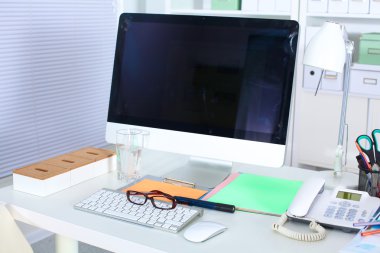 Bir bilgisayar ve evrak ile tasarımcı çalışma masası