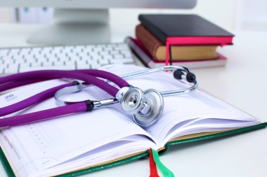 Açık bir kitap bir masada yatan stetoskop