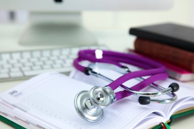 Açık bir kitap bir masada yatan stetoskop