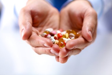 Genç bir doktor hap hastalar eliyle tutan