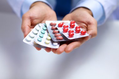 Genç bir doktor hap hastalar eliyle tutan