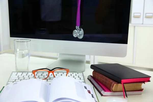 Stetoskop, leżącego na stole na otwartej księdze — Zdjęcie stockowe