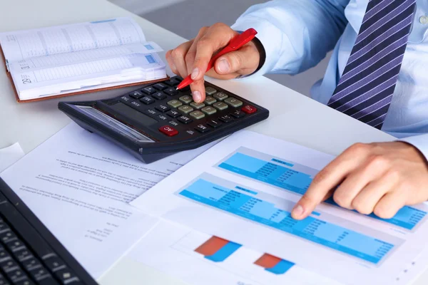 Big boss checks calculations on a calculator — Stock Photo, Image
