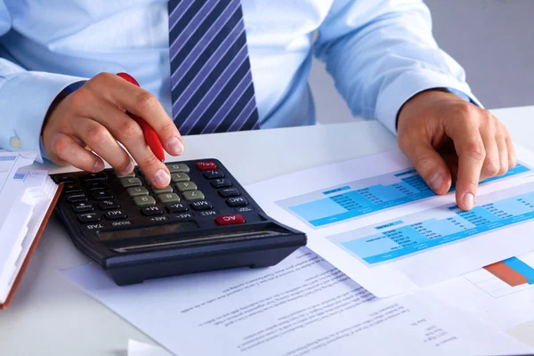 Big boss checks calculations on a calculator — Stock Photo, Image