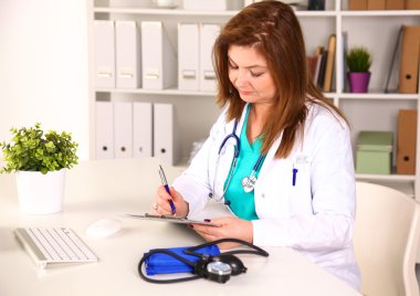 Doktor genç kız ofiste bir masada oturur