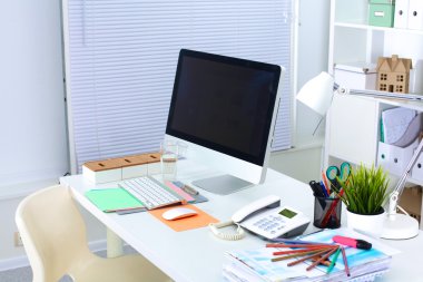 Bilgisayarı ve ahşap masasında akıllı telefonu olan bir ofis.