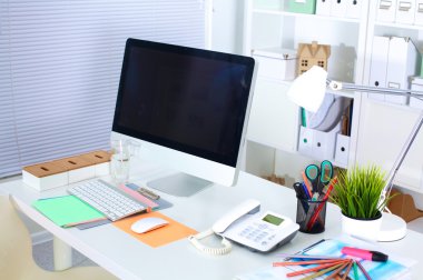 Bilgisayarı ve ahşap masasında akıllı telefonu olan bir ofis.