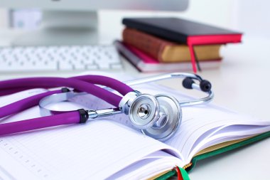 Açık bir kitap bir masada yatan stetoskop