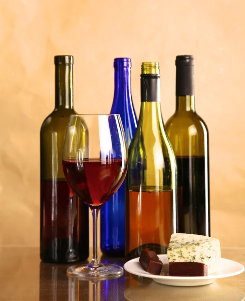 Botella de vino y copa de vino en una mesa de vidrio — Foto de Stock