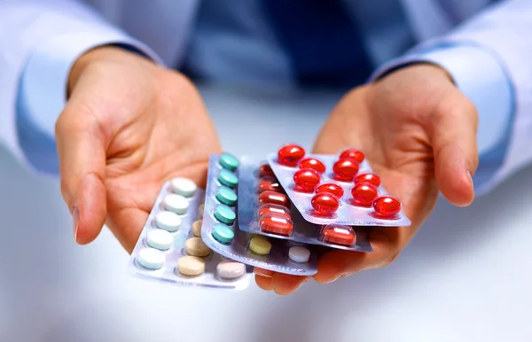 Fiatal orvos gazdaság tabletták a kinyújtott kéz csomagolás — Stock Fotó