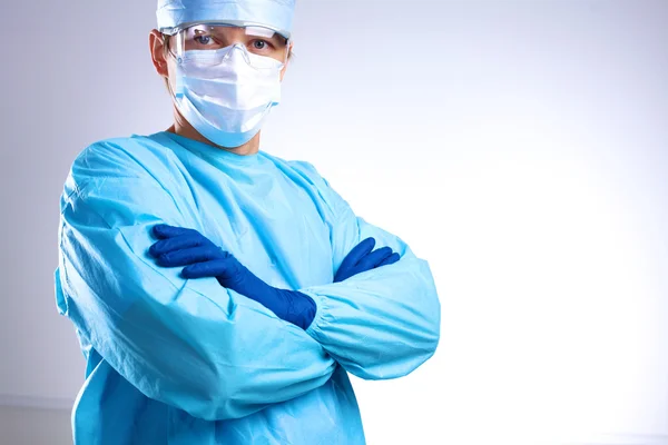 Młody chirurg stojąc z rękami skrzyżowanymi — Zdjęcie stockowe