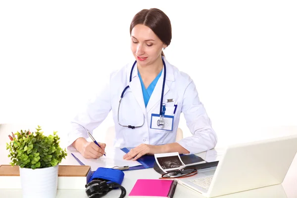 Junge Ärztin sitzt an einem Schreibtisch im Büro — Stockfoto