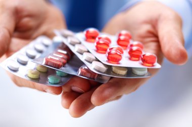 Genç bir doktor hap hastalar eliyle tutan