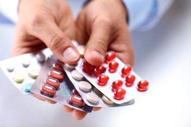 Genç bir doktor hap hastalar eliyle tutan