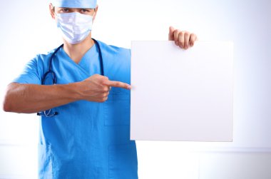 cerrah maskeli bir afişini tutar