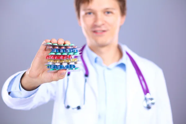 A young doctor holds the patients hand with pills — Stock Photo, Image