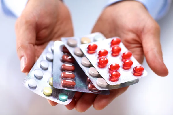 Egy fiatal orvos tartja a beteg kezét tabletták — Stock Fotó