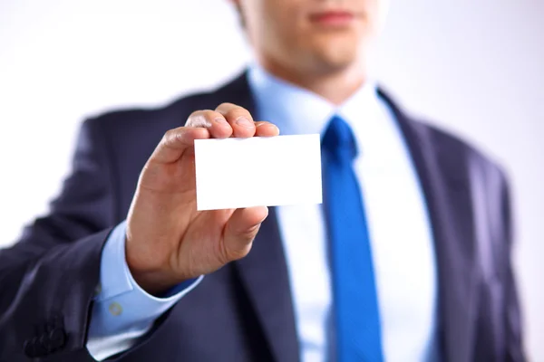Joven hombre de negocios extiende su mano con una tarjeta de visita — Foto de Stock
