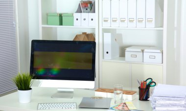 Bir bilgisayar ve evrak ile tasarımcı çalışma masası