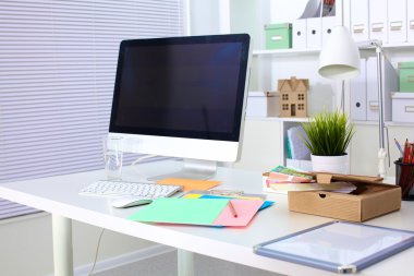 Bir bilgisayar ve evrak ile tasarımcı çalışma masası