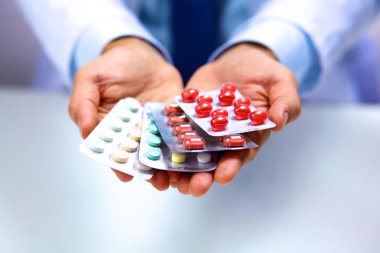 Genç bir doktor hap hastalar eliyle tutan