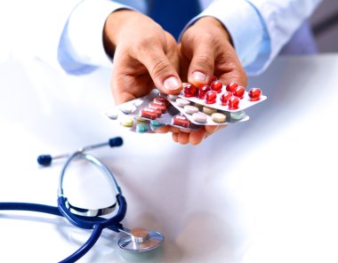 Genç bir doktor hap hastalar eliyle tutan