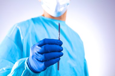 Genç cerrah neşter tutan. İşlem için hazır