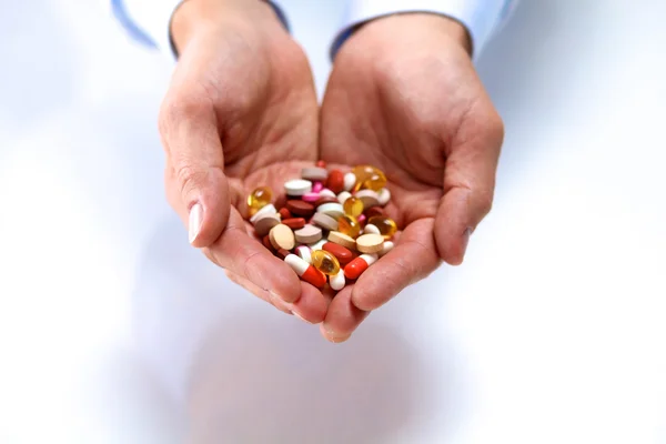 Een jonge dokter houdt de hand van de patiënten met pillen — Stockfoto