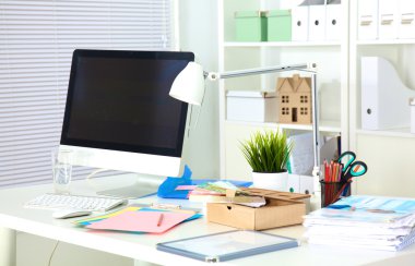 Bir bilgisayar ve evrak ile tasarımcı çalışma masası