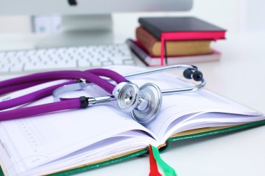 Açık bir kitap bir masada yatan stetoskop