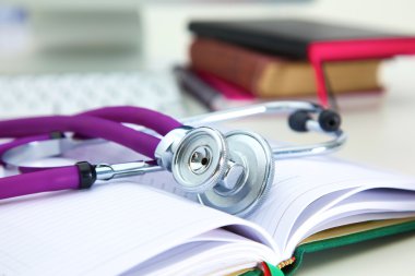 Açık bir kitap bir masada yatan stetoskop
