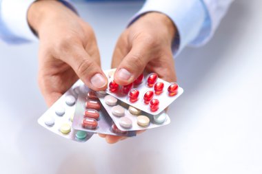 Genç bir doktor hap hastalar eliyle tutan