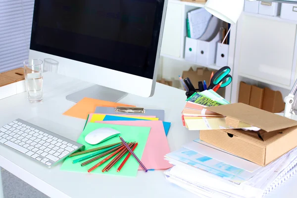 Mesa de trabalho de designer com um computador e papelada — Fotografia de Stock