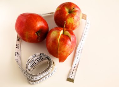 steteskop ile beyaz zemin üzerine kırmızı elmalar