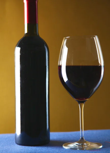 Sobre la mesa una botella de vino y una copa de —  Fotos de Stock