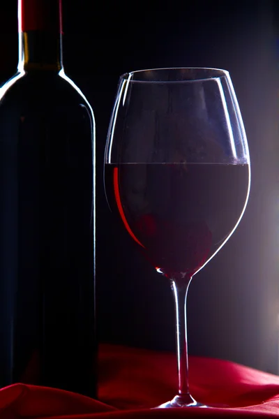 Sobre la mesa una botella de vino y una copa de — Foto de Stock