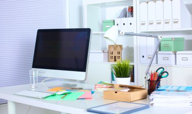 Bilgisayar ve evrak ile tasarımcı çalışma masası