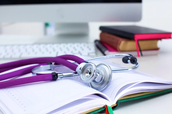 Stethoscope lying on a table an open book — Stock Photo, Image