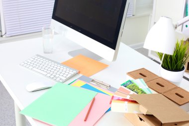 Bilgisayar ve evrak ile tasarımcı çalışma masası