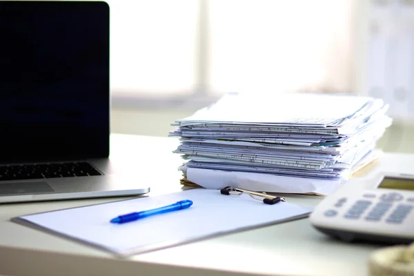 Laptop con pila di cartelle su sfondo bianco tavolo — Foto Stock