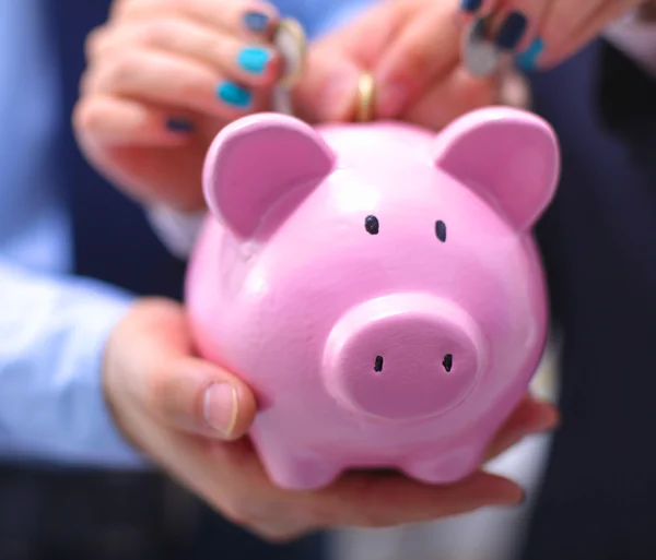 Affärsman holding piggy box, står i office — Stockfoto